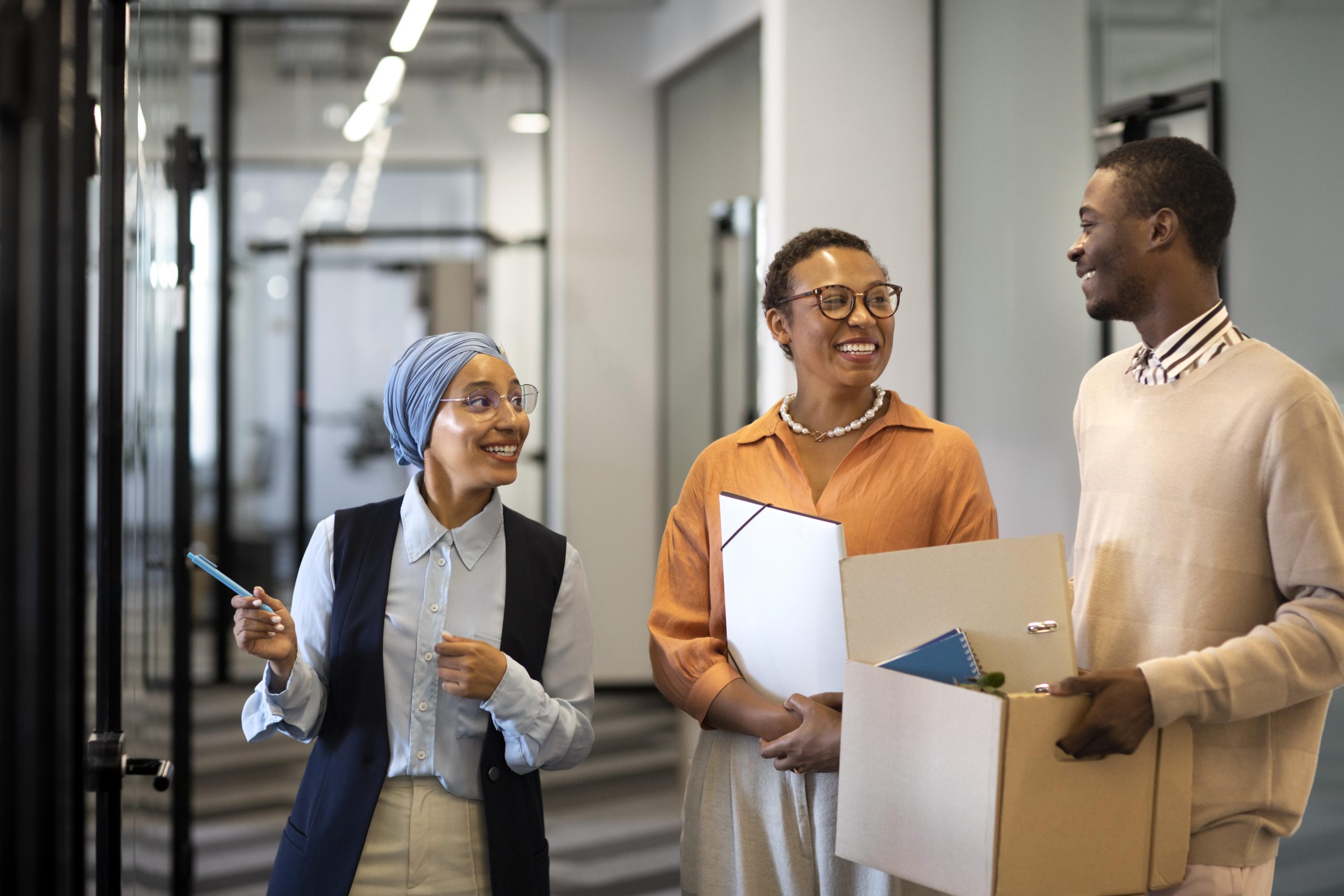 male-employee-exploring-his-new-new-office-job-location-while-carrying-box-belongings-scaled